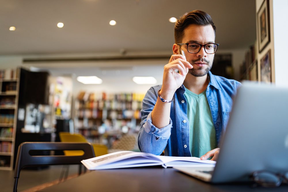 Academic researcher in a library. Academic research data transcription turns audio and video sources into searchable, useable text.